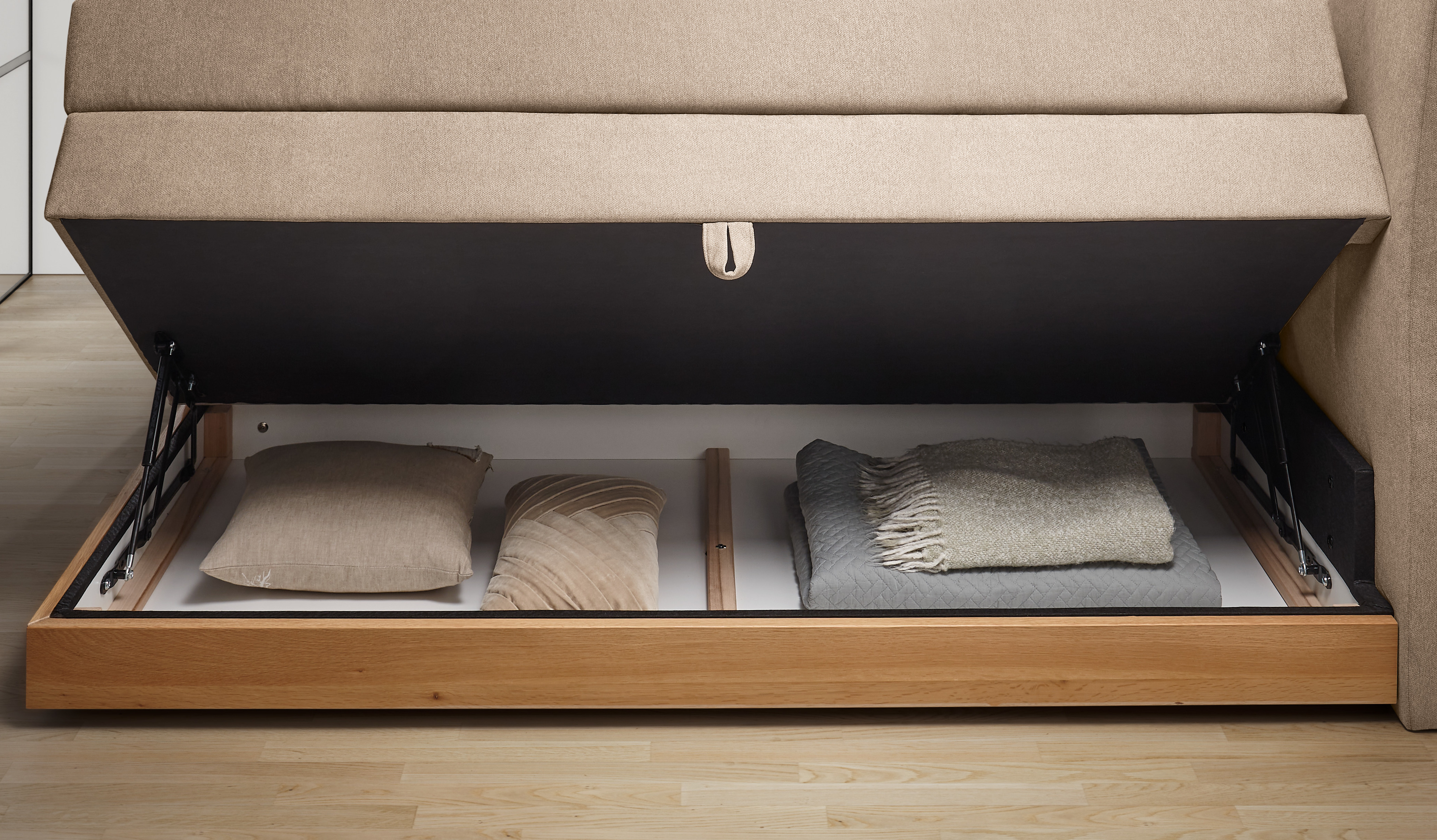Geöffnetes Staufach des Hasena Pronto Boxspringbetts Pedrosa in Pace sand für praktischen Stauraum
